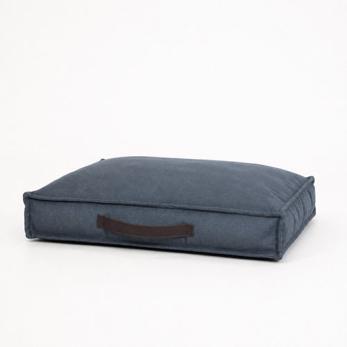 Cama Köff Form Interior en azul, vista de tres cuartos con el mango de cuero
